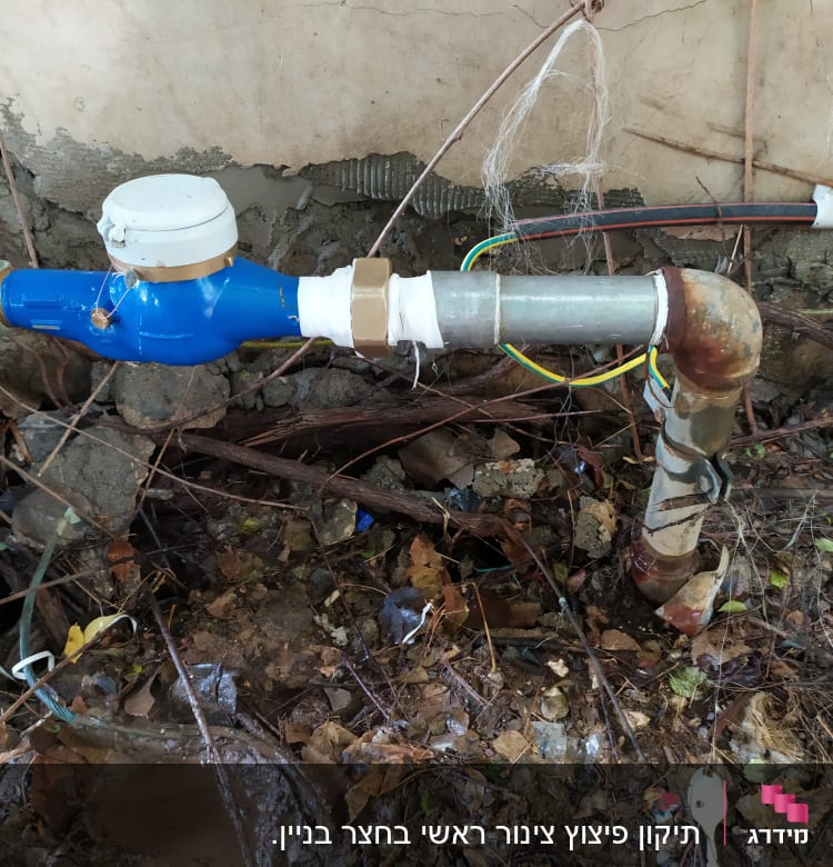 צינור מים עם מד מים כחול וחיבורים חלודים